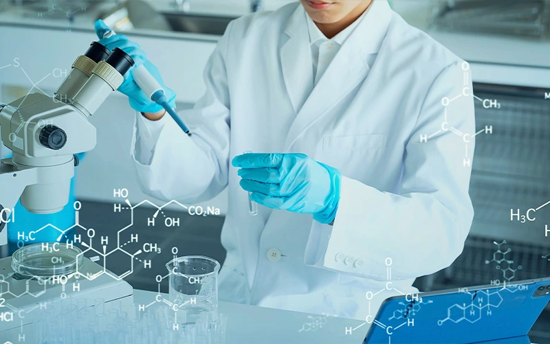 A woman in a lab pouring liquid into a flask