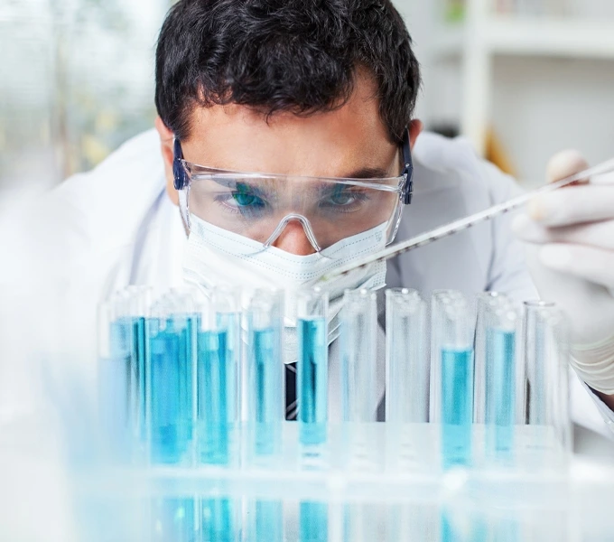 laboratory researcher pouring liquid into vials